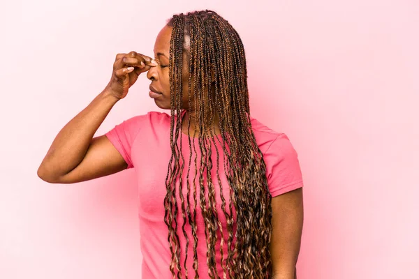 Genç Afrikalı Amerikalı kadın pembe arka planda izole edilmiş, başı ağrıyor, yüzüne dokunuyor..