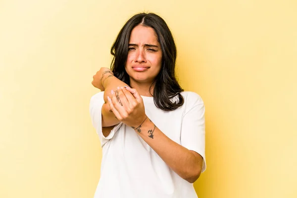 ストレス マッサージ 手でそれに触れるために首の痛みを持つ黄色の背景に隔離された若いヒスパニック系の女性 — ストック写真