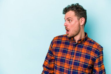 Kafkasyalı genç adam mavi arka planda izole edilmişti. Gördüğü bir şey yüzünden şok olmuştu..