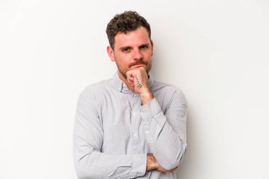 Beyaz arka planda izole edilmiş genç beyaz bir adam şüpheli, belirsiz, seni muayene ediyor..