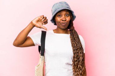 Genç Afrikalı Amerikalı bir kadın pembe arka planda izole edilmiş bir şekilde sahile gidiyor. Hoşlanmadığı bir jest yapıyor. Anlaşmazlık konsepti.