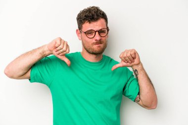 Beyaz arka planda izole edilmiş genç beyaz adam baş parmağını aşağı gösteriyor, hayal kırıklığı konsepti..