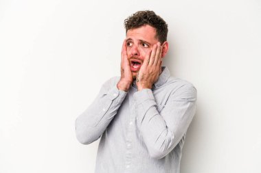 Beyaz arka planda izole edilmiş genç beyaz adam korkmuş ve korkmuş..