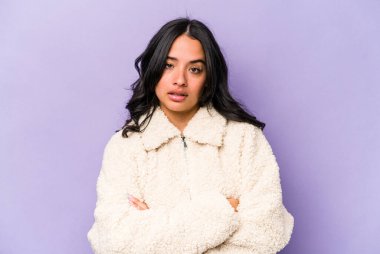 Mor arka planda soyutlanmış genç İspanyol bir kadın. Sıkılmış, yorgun ve dinlenmeye ihtiyacı var..