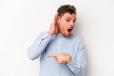 Beyaz arka planda izole edilmiş genç beyaz adam bir dedikoduyu dinlemeye çalışıyor..