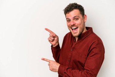 Beyaz arka planda izole edilmiş genç beyaz bir adam işaret parmağıyla fotokopi alanını işaret ederek heyecan ve arzusunu ifade ediyor..