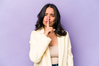 Mor arka planda izole edilmiş genç İspanyol kadın ya sır saklıyor ya da sessizlik istiyor..