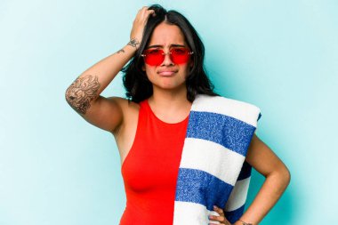 Mavi arka planda izole edilmiş plaj havlusu tutan genç İspanyol kadın şok geçiriyordu. Önemli bir toplantıyı hatırladı..