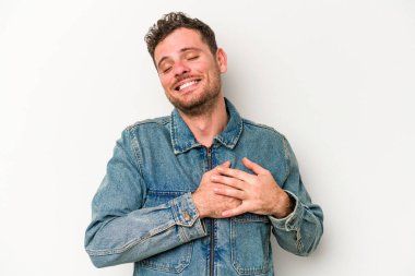 Beyaz arka planda izole edilmiş beyaz tenli genç bir adam, dostane bir ifadeye sahip, avuçlarını göğsüne bastırıyor. Aşk konsepti.