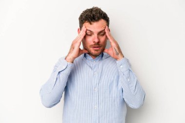 Beyaz arka planda izole edilmiş genç beyaz bir adam tapınaklara dokunuyor ve başı ağrıyor..