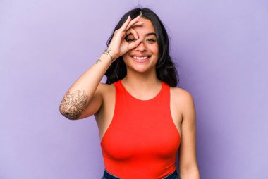 Mor arka planda izole edilmiş genç bir İspanyol kadın heyecanlı..