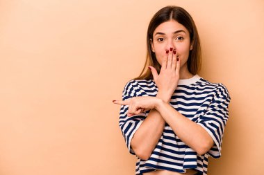 Latin kökenli genç bir kadın bej arka planda izole edilmiş.