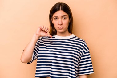 Latin kökenli genç bir kadın bej arka planda izole edilmiş, hoşlanmadığı bir jest gösteriyor. Anlaşmazlık konsepti.