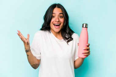 Mavi arka planda termometreyi tutan genç İspanyol kadın hoş bir sürprizle karşılaşıyor, heyecanlı ve el kaldırıyor..