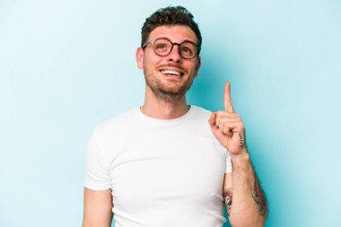 Mavi arka planda izole genç beyaz adam işaret iki ön parmakları boş bir boşluk gösteren.