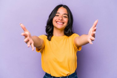 Mor arka planda izole edilmiş genç İspanyol kadın kameraya sarıldığı için kendinden emin..