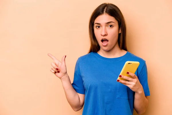 Elinde Cep Telefonu Olan Beyaz Bir Kadın Bej Arka Planda — Stok fotoğraf