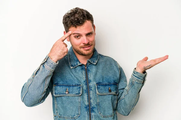 Beyaz arka planda izole edilmiş genç beyaz bir adam işaret parmağıyla hayal kırıklığı jesti gösteriyor..