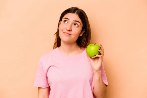 Young Hispanic Woman Holding Apple Isolated Beige Background Dreaming Achieving — Stock Photo, Image