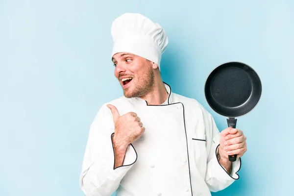 年轻的高加索厨师拿着用蓝底尖隔开的飞行锅 无忧无虑地笑了笑 无忧无虑 — 图库照片