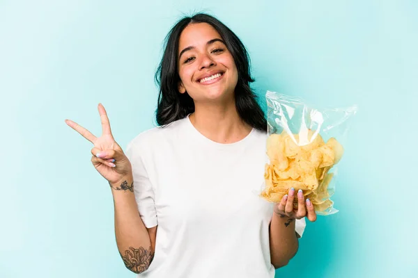 Ung Latinamerikansk Kvinna Håller Påse Chips Isolerade Blå Bakgrund Glad — Stockfoto