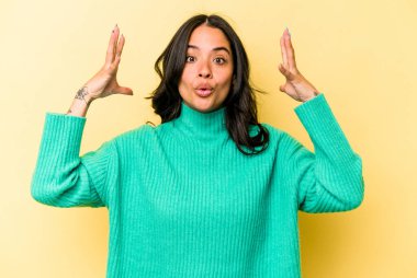 Sarı arka planda, zaferi ya da başarıyı kutlayan genç İspanyol kadın şaşırdı ve şok oldu..