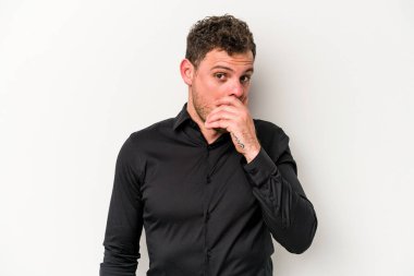 Beyaz arka planda izole edilmiş genç beyaz bir adam ağzı kapalı ve elleri endişeli görünüyor..