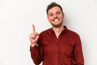 Beyaz arka planda izole edilmiş beyaz tenli genç bir adam bir numarayı parmağıyla gösteriyor..
