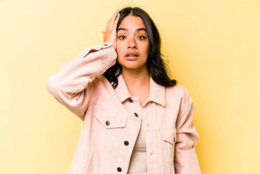 Sarı arka planda izole edilmiş genç İspanyol kadın şok geçiriyordu. Önemli bir buluşmayı hatırladı..