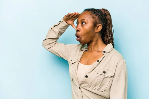 Ung Afrikansk Amerikansk Kvinna Isolerad Blå Bakgrund Ser Långt Borta — Stockfoto