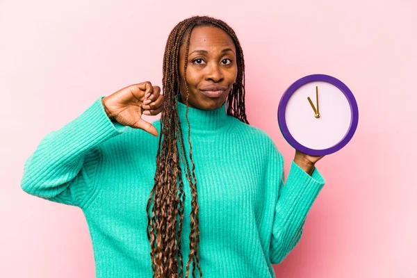 Ung Afroamerikansk Kvinna Håller Klocka Isolerad Rosa Bakgrund Visar Motbjudande — Stockfoto