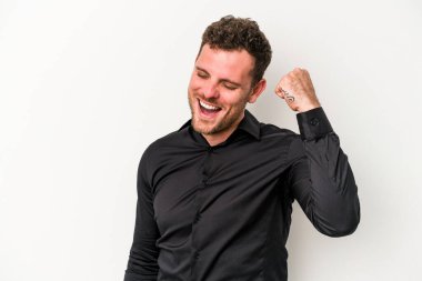 Beyaz arka planda izole edilmiş genç beyaz bir adam zaferi, tutkuyu ve coşkuyu kutluyor, mutlu bir ifade..