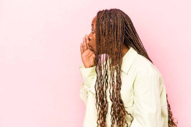 Pembe arka planda izole edilmiş genç Afrikalı Amerikalı kadın gizli bir fren haberinin olduğunu söylüyor.