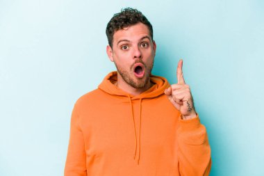 Kafkasyalı genç bir adam mavi arka planda izole edilmiş. Bir fikri, ilham verici bir fikri var..