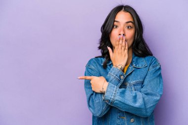 Mor arka planda izole edilmiş genç İspanyol kadın yan tarafı gösteriyor.
