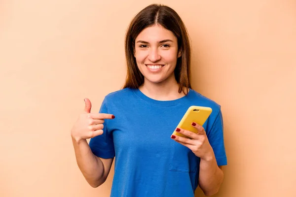 Mujer Caucásica Joven Sosteniendo Teléfono Móvil Aislado Sobre Fondo Beige —  Fotos de Stock