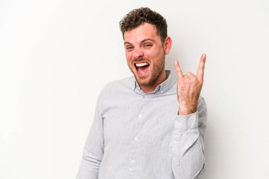 Beyaz arka planda izole edilmiş genç beyaz bir adam boynuzlarını devrim konsepti olarak gösteriyor..