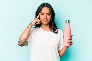 Mavi arka planda termometreyi tutan genç İspanyol kadın parmağıyla tapınağı işaret ediyor, düşünüyor ve bir göreve odaklanıyor..