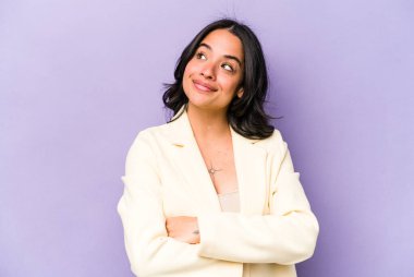 Mor arka planda izole edilmiş genç İspanyol kadın hedeflerine ve amaçlarına ulaşma hayali kuruyor.