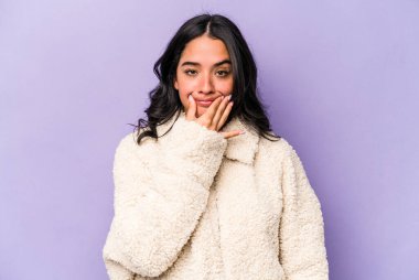 Mor arka planda izole edilmiş genç İspanyol kadın iki seçenek arasında şüphe duyuyor.