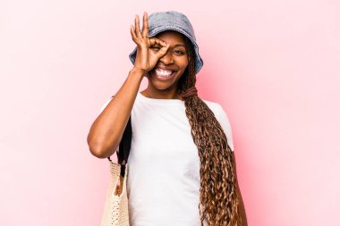 Genç Afrikalı Amerikalı kadın plaja gidiyor. Pembe arka planda izole edilmiş. Heyecanlı..