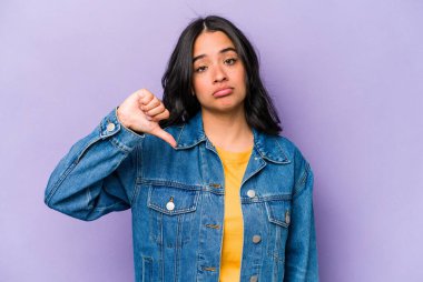 Mor arka planda izole edilmiş genç İspanyol kadın hoşlanmadığı bir hareket gösteriyor. Anlaşmazlık konsepti.