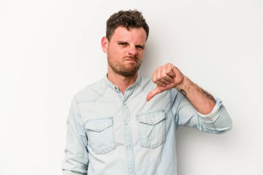 Beyaz arka planda izole edilmiş genç beyaz adam baş parmağını aşağı gösteriyor, hayal kırıklığı konsepti..