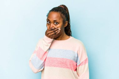 Genç Afrikalı Amerikalı kadın mavi arka planda izole edilmiş ağzı kapalı ve elleri endişeli görünüyor..