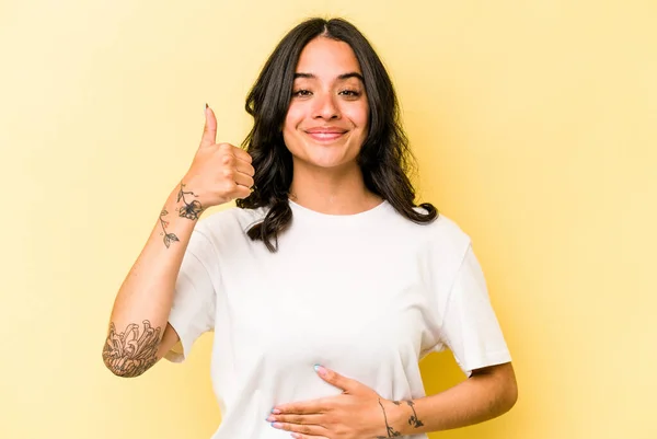 Young Hispanic Woman Isolated Yellow Background Touches Tummy Smiles Gently — 스톡 사진