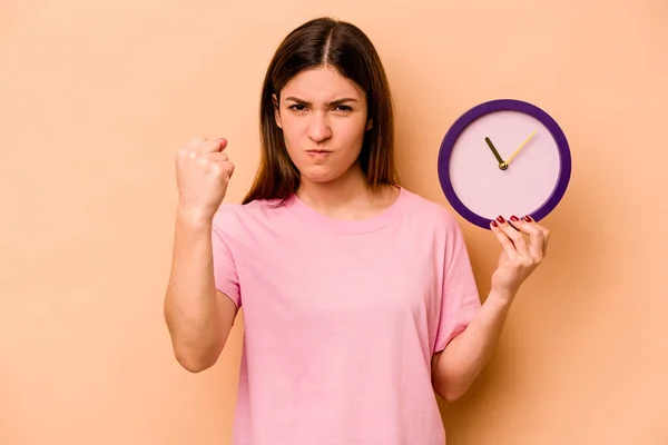 Mujer Hispana Joven Sosteniendo Reloj Aislado Sobre Fondo Beige Mostrando — Foto de Stock