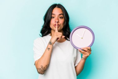 Mavi arka planda bir saat tutan genç İspanyol kadın bir sır saklıyor ya da sessizlik istiyor..