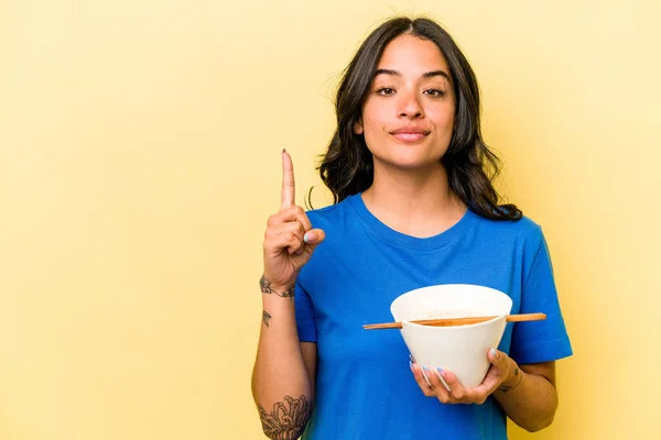 Jonge Latino Vrouw Eten Ramen Geïsoleerd Blauwe Achtergrond Tonen Nummer — Stockfoto