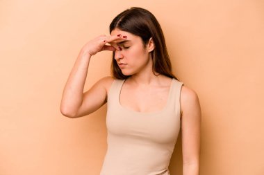 Latin kökenli genç bir kadın bej arka planda izole edilmiş, başı ağrıyor, yüzüne dokunuyor..