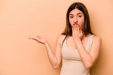 Latin kökenli genç bir kadın, bej arka planda izole edilmiş..